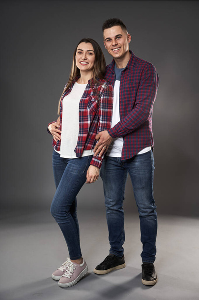 Young caucasian couple posing against gray background - Foto, afbeelding