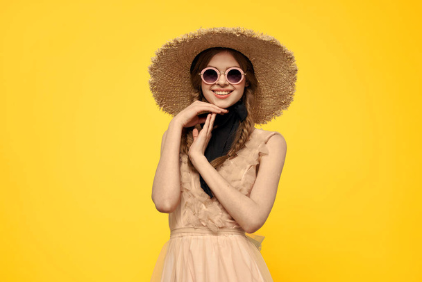 Kobieta w okrągłych okularach w słomkowym kapeluszu przycięty widok żółtego tła - Zdjęcie, obraz