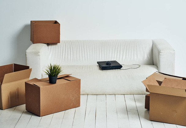 Коробки с вещами белый диван распаковывать офис переезда - Фото, изображение