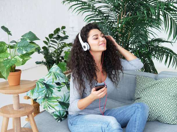 Beautiful Afro American woman in headphones is listening to music - Foto, Imagen