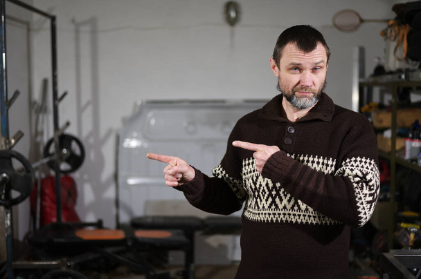 Portrait of an adult man in a garage with emotions in different poses - Fotografie, Obrázek