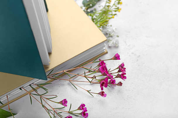 Books with fresh flowers on light background, closeup - Photo, Image