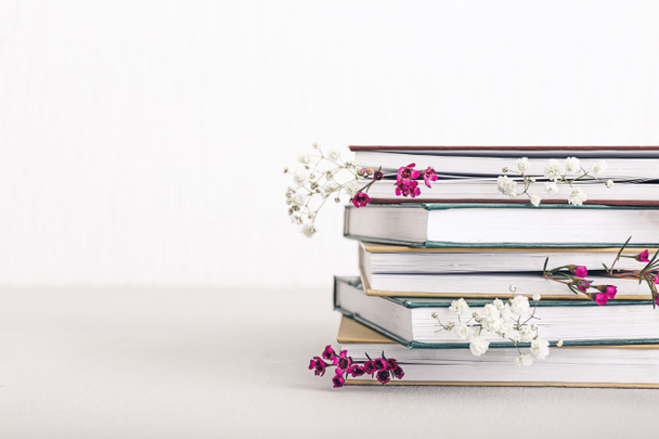 Books with fresh flowers on white background - Фото, изображение