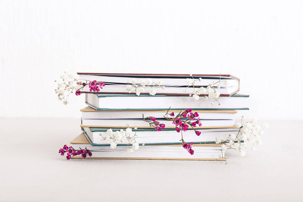 Books with fresh flowers on white background - Фото, изображение