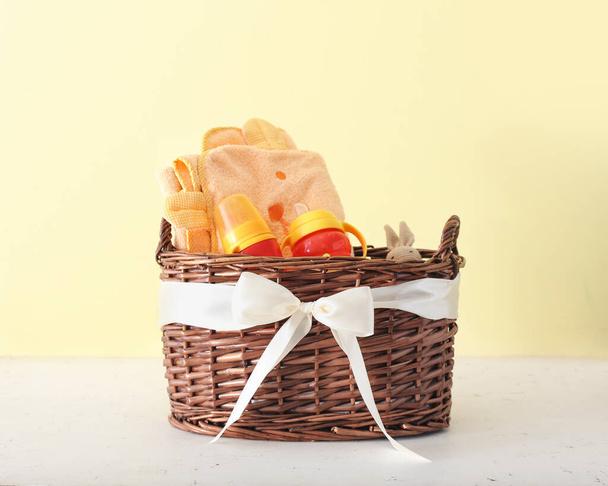 Wicker basket with gifts for baby on color background - Foto, Imagem
