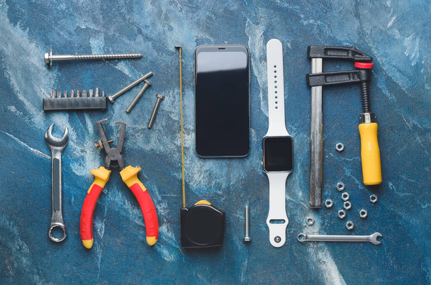 Набір інструментів з мобільним телефоном та розумним годинником на кольоровому фоні
 - Фото, зображення