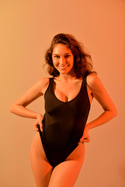 Belle jeune femme en maillot de bain sur fond de couleur - Photo, image