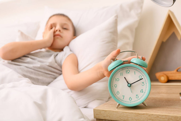 Morning of sleepy little boy turning off alarm clock - Фото, изображение