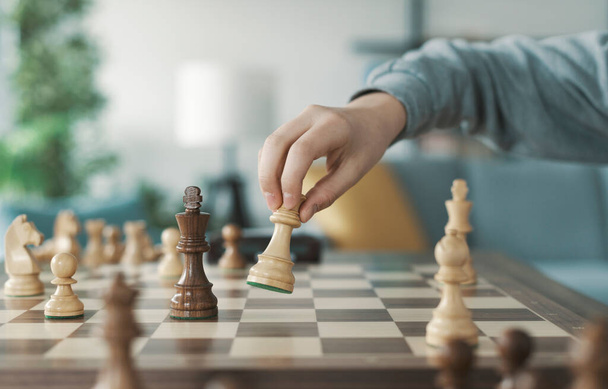 Intelligens fiú sakkozik otthon, ő mozog egy darab a sakktáblán - Fotó, kép