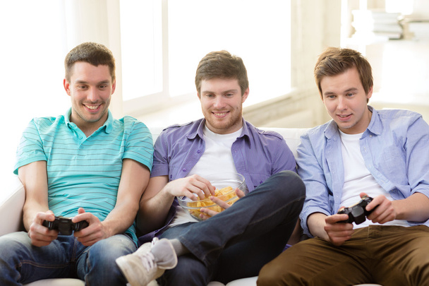 smiling friends playing video games at home - Valokuva, kuva