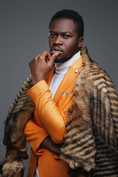 Cool african man with fur against gray background - Photo, Image