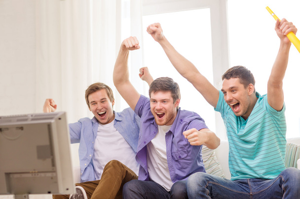 happy male friends with vuvuzela watching sports - Фото, зображення