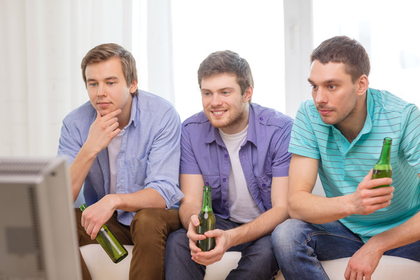 happy male friends with beer watching tv at home - Photo, image