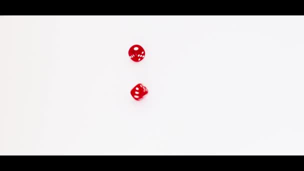 Slow motion footage of a rolling dice on white background. Indoors - Footage, Video