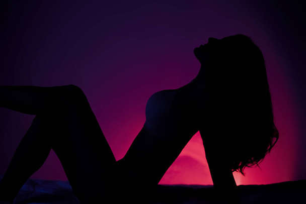 Сексуальна жінка позує на червоному темному тлі
 - Фото, зображення