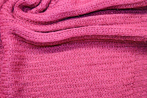 Motif textile tricoté rose comme fond. Gros plan sur la texture en tricot rose sur le tissu. texture de tissu froissé - Photo, image