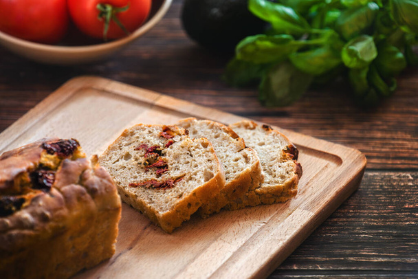 Horizontal view of sliced wheat rye sourdough bread stuffed with sun-dried tomatoes and rosemary. - Foto, Imagem