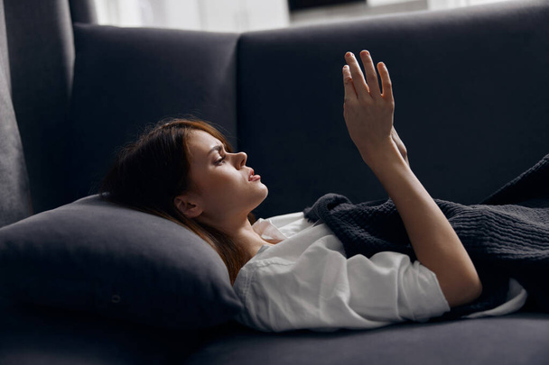 mulher deitada no sofá com um telefone celular nas mãos - Foto, Imagem