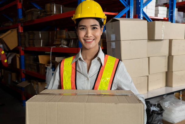 Портрет молодой азиатки, работающей на складе, улыбающейся на складе - Фото, изображение
