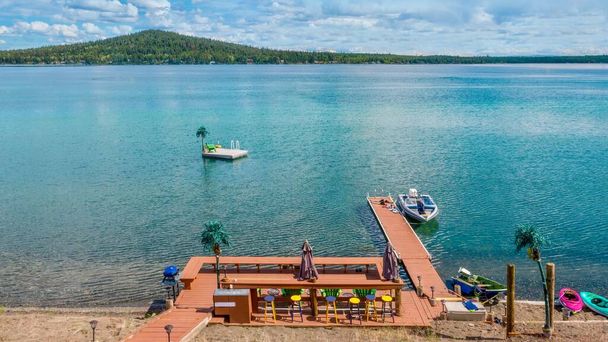 Wysoki kąt widok na prywatny teren rekreacyjny nad jeziorem, w tym drewniany pokład, dok, łodzie, kajaki, siedzenia i akcesoria. Green Lake, Kolumbia Brytyjska, Kanada. - Zdjęcie, obraz