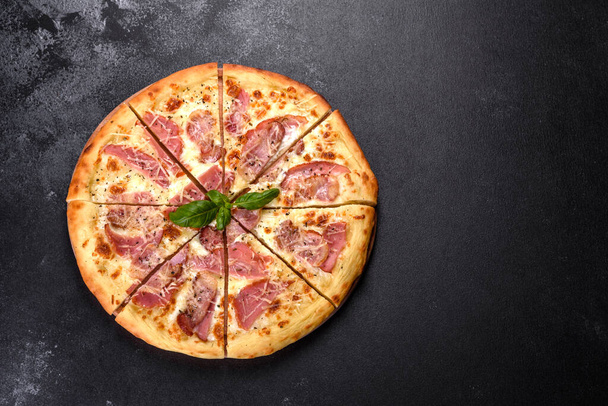 Deliciosa pizza crujiente fresca del horno con jamón, queso y albahaca. Cocina italiana - Foto, imagen