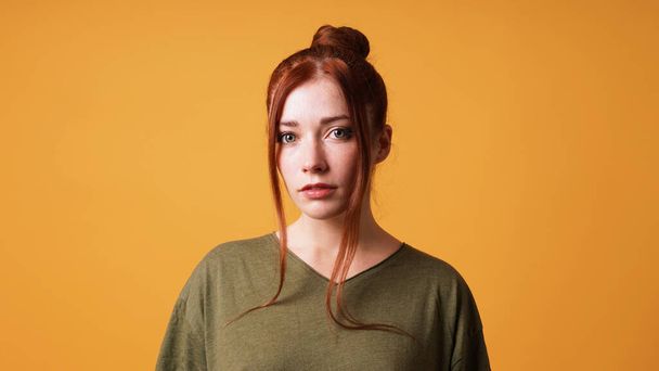 portrait of pretty young woman with red hair bun and curtain bangs - Foto, imagen