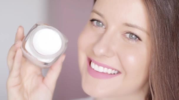 Vrouw met hydraterende gezichtscrème pot, ochtend routine en natuurlijke make-up look, luxe huidverzorging en spf huidbescherming, biologische schoonheid en wellness product - Video