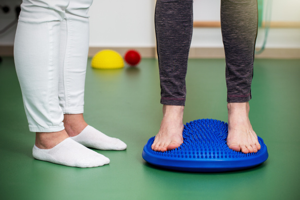 Patient with flat feet standing on a spiky massage pad - Photo, Image