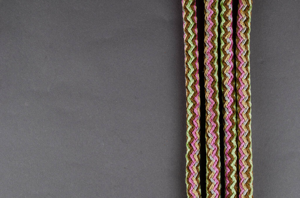 Univerzální propylenové lano na šedém pozadí. Kulaté vícebarevné pletené lano ze syntetických vláken s jádrem. Pohled shora, plochý. Kopírovat prostor. - Fotografie, Obrázek