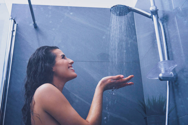 Доросла жінка під душем у ванній
 - Фото, зображення