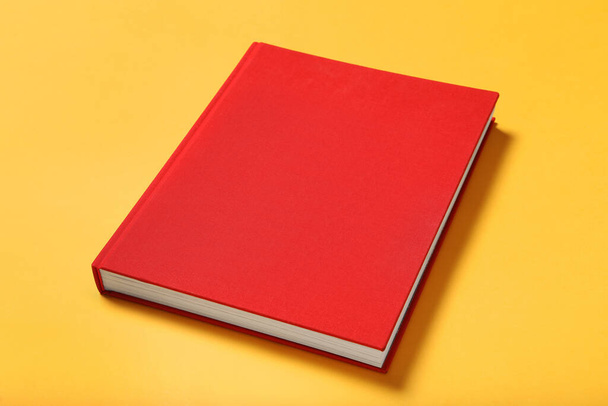 Book with red cover on yellow background - Foto, Imagem