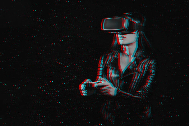 Girl joue à des jeux informatiques modernes dans des lunettes de réalité virtuelle. Joueur émotionnel avec un joystick dans ses mains est immergé dans le monde de la réalité augmentée - Photo, image