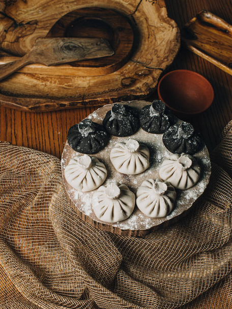 Raw khinkali in flour on the table - Foto, afbeelding
