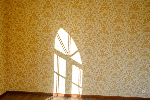 Zimmer mit beiger Tapete, Spiegelung eines Fensters mit Solarlicht an der Wand - Foto, Bild