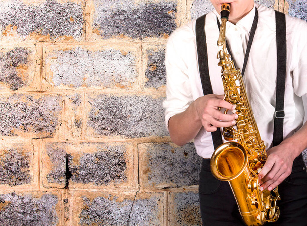 Tyylikäs nuori mies valkoisessa paidassa saksofonilla - Valokuva, kuva