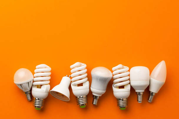 Many light bulbs on bright orange background - Foto, immagini
