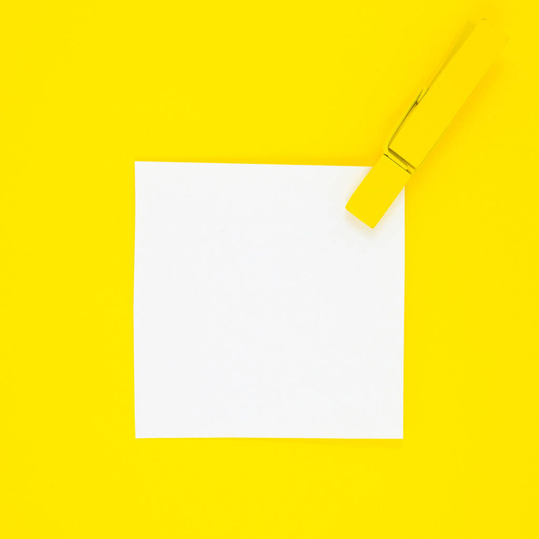Blanco witte To Do List Sticker met gele houten wasknijper. Sluiten van herinneringsnota papier op de gele achtergrond. Begrepen, ruimte. Minimalisme, originele en creatieve foto. - Foto, afbeelding