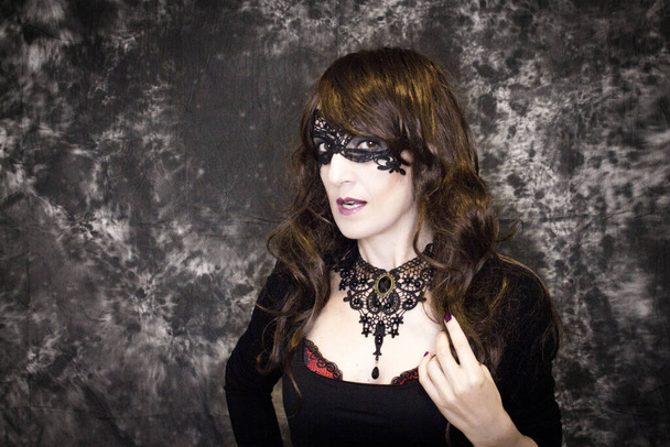 仮面をつけたハロウィンパーティーのためのゴシック様式で変装した女性 - 写真・画像