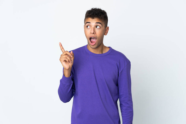 Young brazilian man isolated on white background intending to realizes the solution while lifting a finger up - Photo, Image