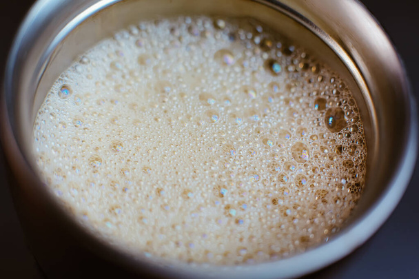 Close up colorato caffè e verdura schiuma di latte d'avena bolle all'interno di acciaio inox thermos metallo tazza, shaker, macro bevanda calda - Foto, immagini