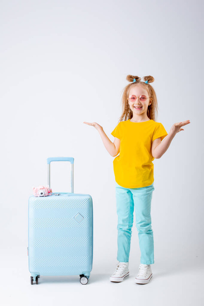 little girl traveler with a suitcase on a white background - Foto, Imagem