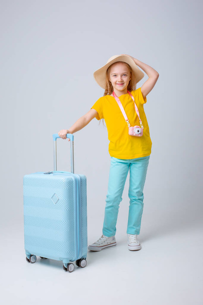 viajero niña con una maleta sobre un fondo blanco - Foto, Imagen