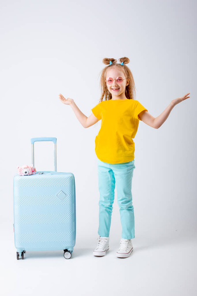 little girl traveler with a suitcase on a white background - Foto, Bild