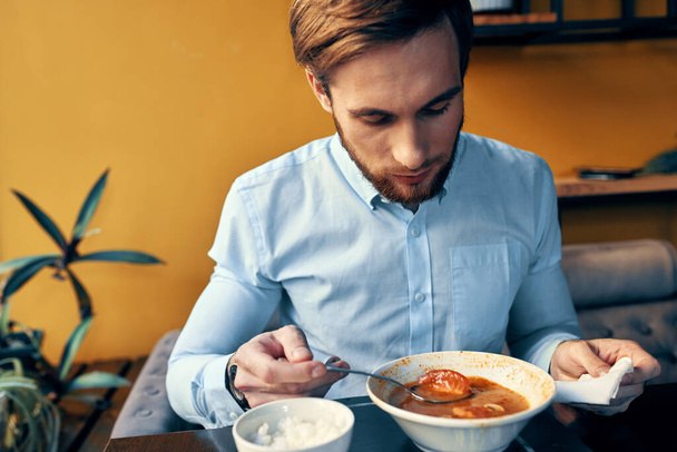 homem almoçando em um restaurante caldo quente comida pausa no trabalho - Foto, Imagem