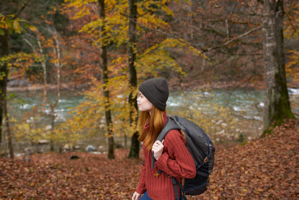 oldalnézetben boldog nő a parkban ősszel közel folyó  - Fotó, kép