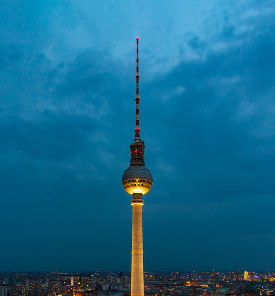 Μια φωτογραφία του Berliner Fernsehtturm με θέα το αστικό τοπίο του Βερολίνου, τη νύχτα. - Φωτογραφία, εικόνα
