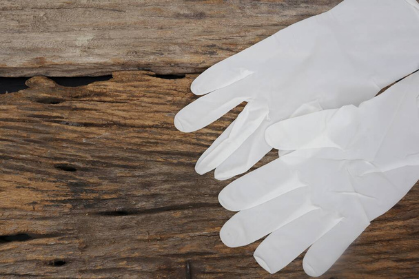 Резиновые перчатки медицинские хирургические перчатки латексные перчатки на заднем плане деревянного стола - Фото, изображение