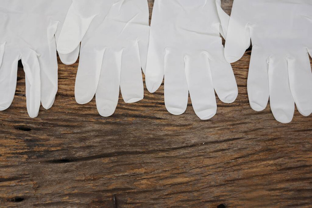 Резиновые перчатки медицинские хирургические перчатки латексные перчатки на заднем плане деревянного стола - Фото, изображение