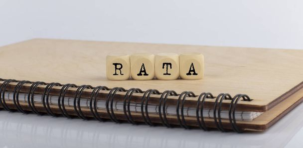 word RATA made with letters on the wooden blocks on wooden notepad - 写真・画像