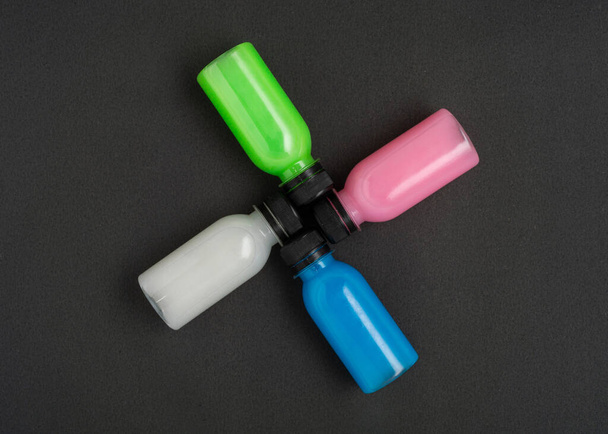 Colorful liquid in a bottles on black background. Flat lay. - Foto, Imagen